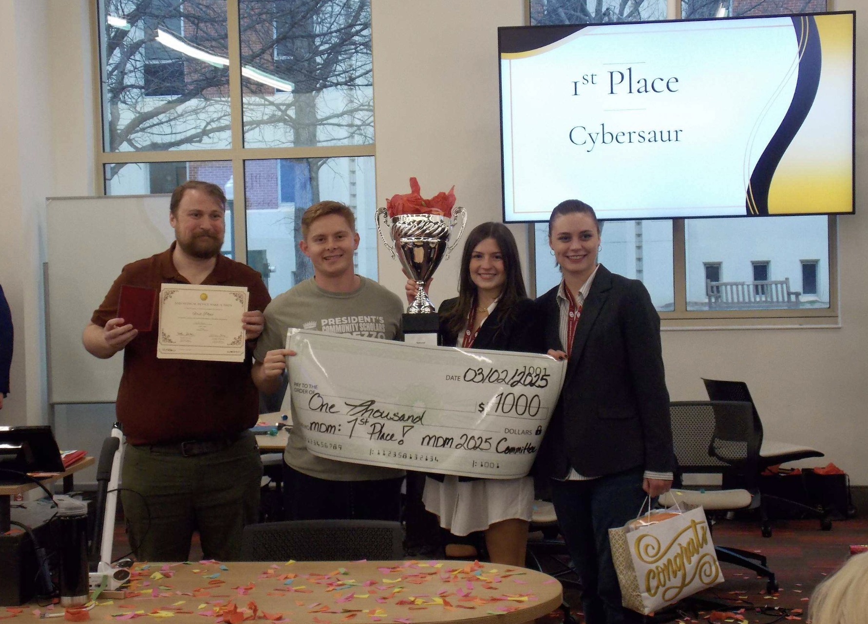First-place team at the 2025 Medical Device Make-A-Thon holding their trophy, certificate, and award check